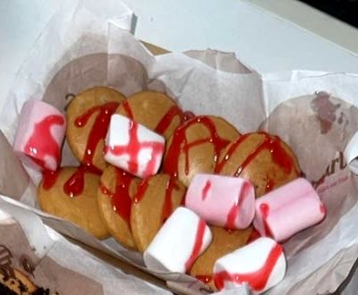 Mini pancakes with marshmallows and a red drizzle