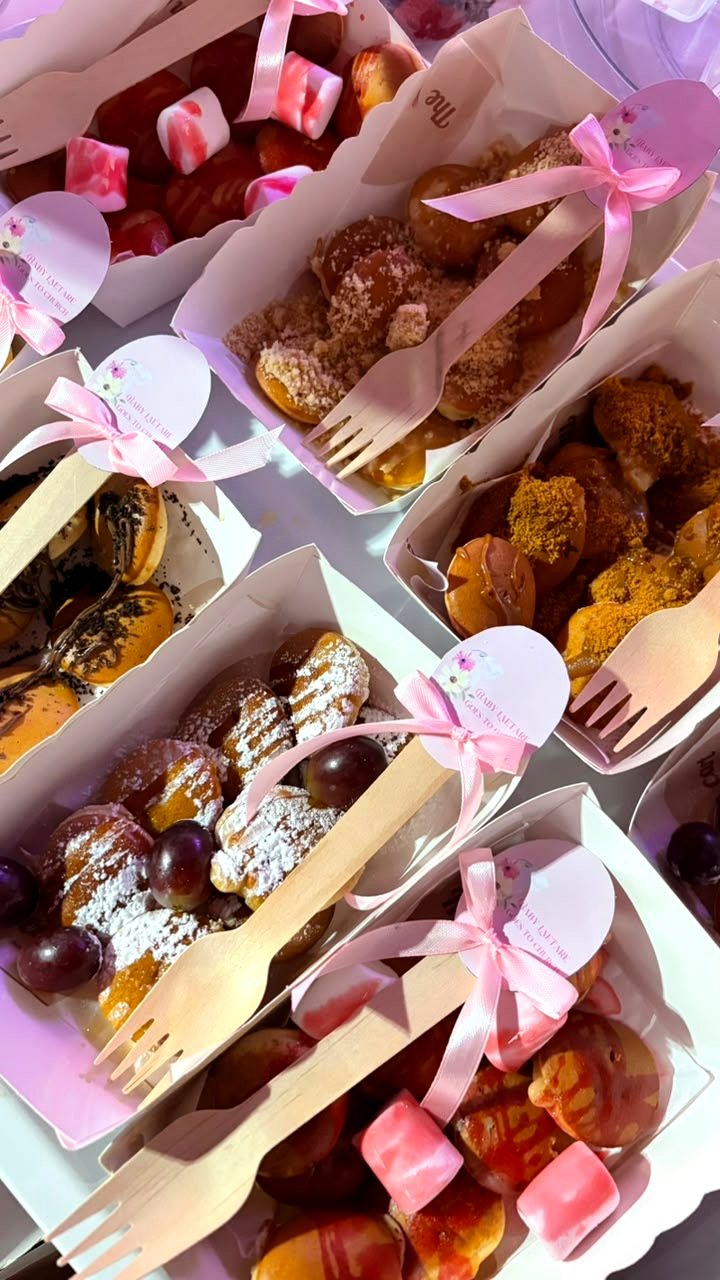 Boxes of mini pancakes with wooden forks tied with pink ribbons and custom tags